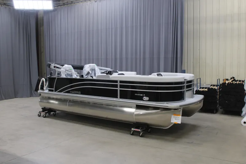 The Image of 2026 Harris Cruiser 210 pontoon boat in a showroom, featuring sleek design and modern amenities. - 1