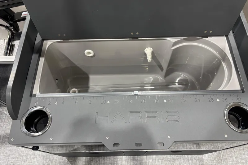 Slide: The Image of 2026 Harris Cruiser 210 boat storage compartment with built-in measuring ruler and cup holders. - 12