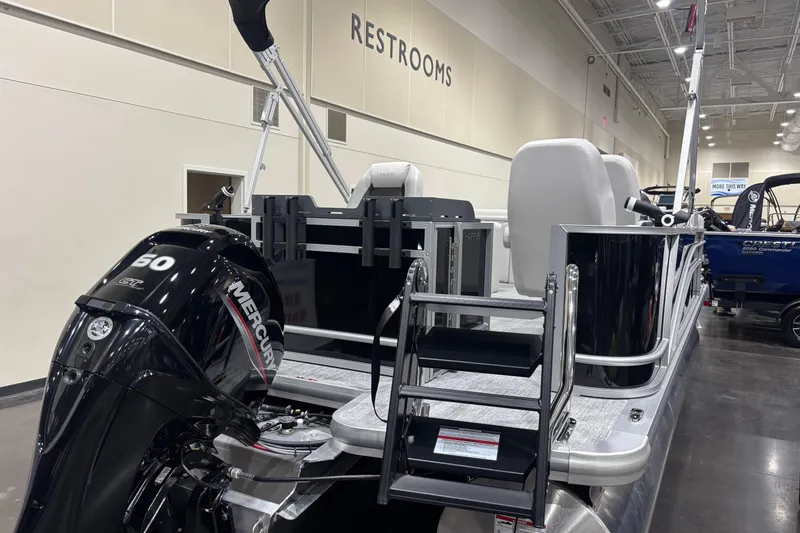 Slide: The Image of 2026 Harris Cruiser 210 boat with Mercury engine displayed indoors. - 14