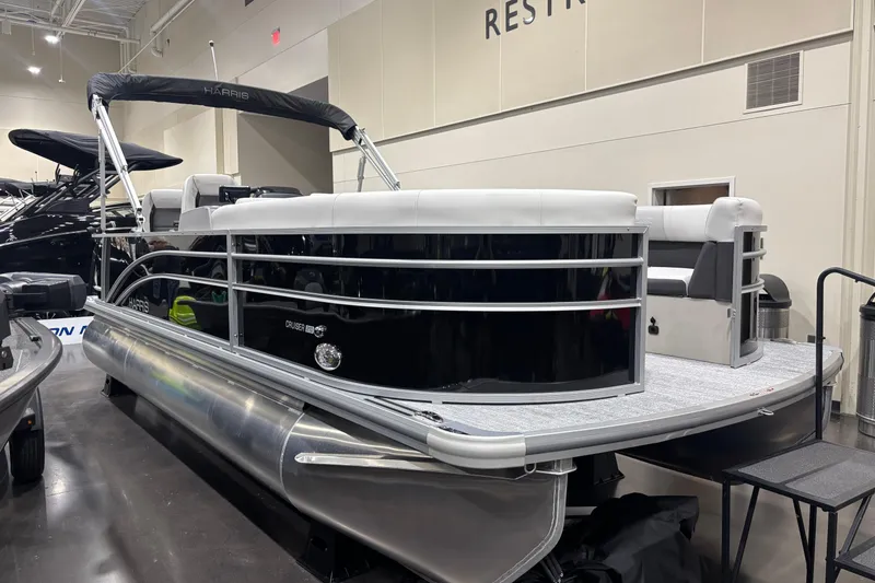 The Image of 2026 Harris Cruiser 210 pontoon boat displayed indoors, featuring sleek design and modern seating. - 3