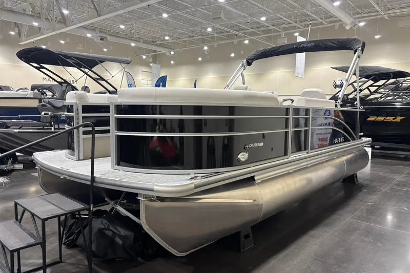 Slide: The Image of 2026 Harris Cruiser 210 pontoon boat displayed indoors at a boat show. - 5