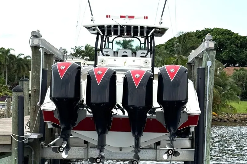 Slide: The Image of 2013 Hydra-Sports 42 boat with four powerful outboard engines docked by the water. - 2