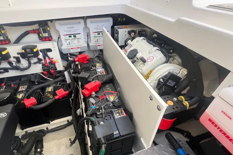 Slide: The Image of Engine compartment of 2025 Sea Ray Sundancer 320 Coupe with batteries and wiring. - 14