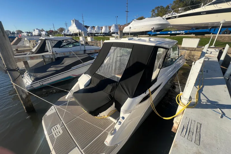 Slide: The Image of 2025 Sea Ray Sundancer 320 Coupe docked at marina, rear view. - 2