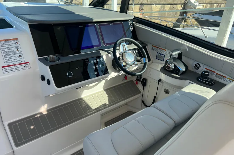 Slide: The Image of Interior cockpit of 2025 Sea Ray Sundancer 320 Coupe with modern controls and steering. - 3