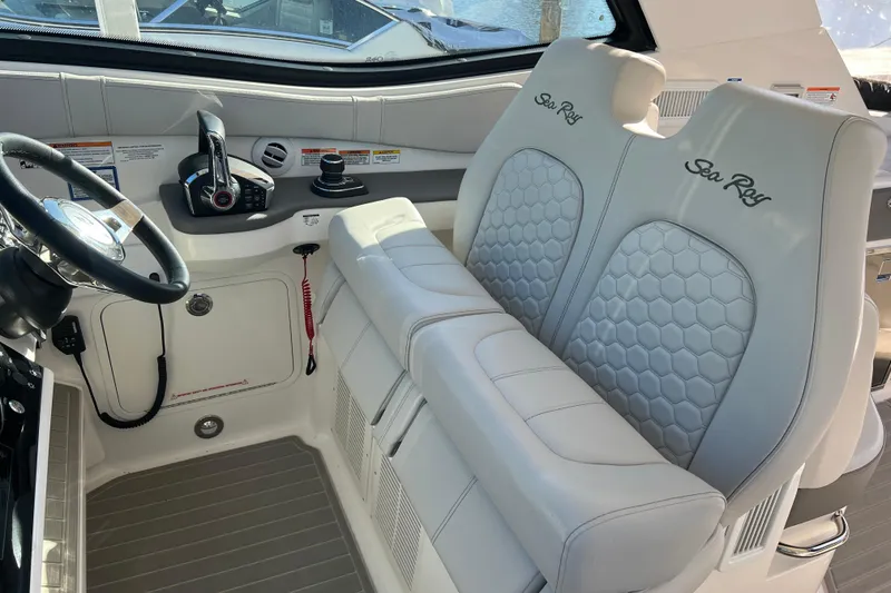 Slide: The Image of 2025 Sea Ray Sundancer 320 Coupe cockpit with luxurious seating and modern controls. - 7