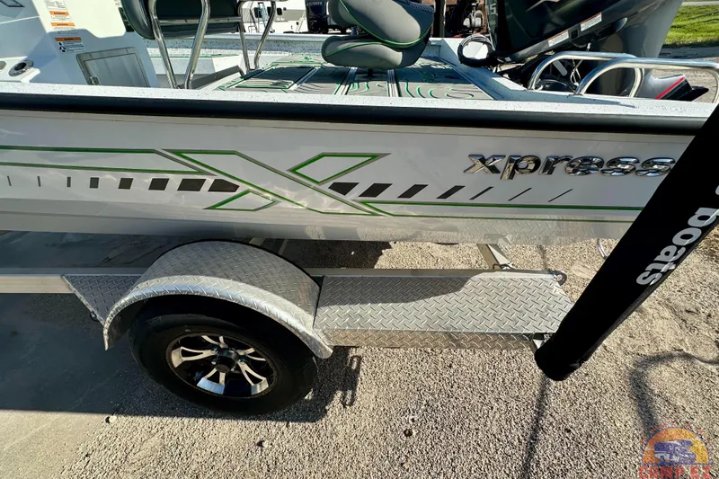 Slide: The Image of 2024 Xpress H20B Bay boat on trailer, featuring sleek design and green accents. - 10