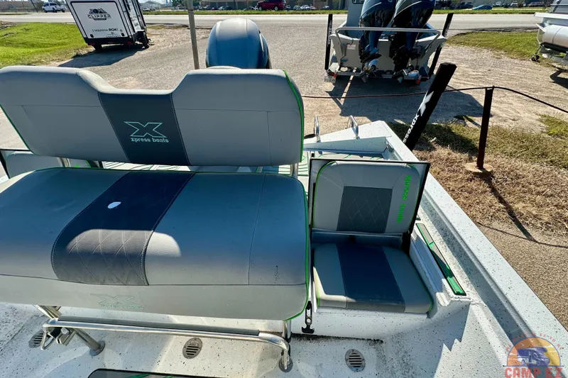 Slide: The Image of 2024 Xpress H20B Bay boat interior with cushioned seating and dual outboard motors. - 19