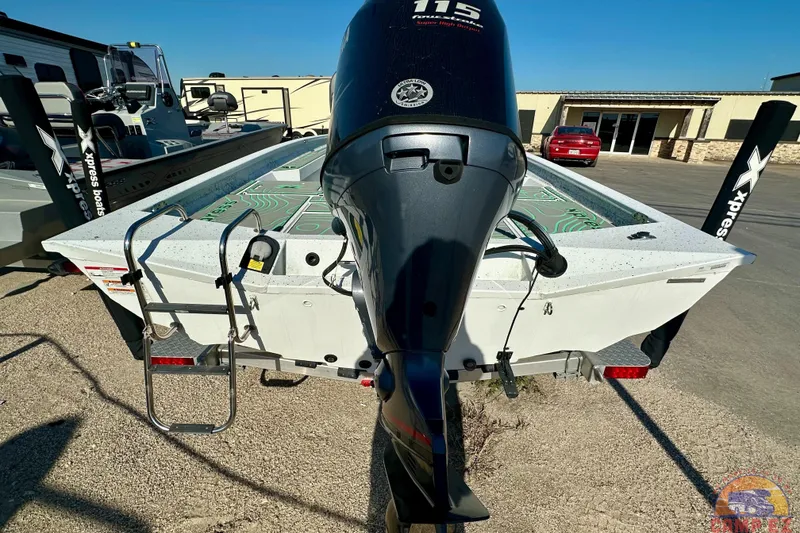 Slide: The Image of 2024 Xpress H20B Bay boat with outboard motor and trailer, parked outdoors. - 6