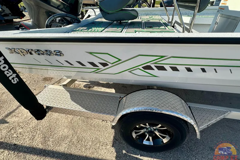 Slide: The Image of 2024 Xpress H20B Bay boat with green graphics on a trailer. - 9