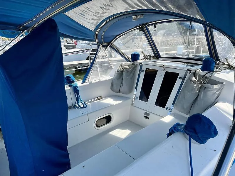 Slide: The Image of Interior view of a 2000 Catalina 320 sailboat cockpit with blue canopy and seating. - 17