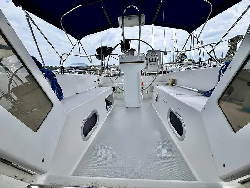 Slide: The Image of Cockpit view of a 2000 Catalina 320 sailboat with blue canopy and steering wheel. - 26
