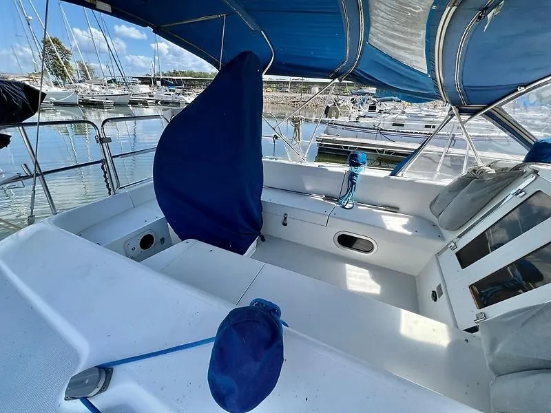 Slide: The Image of 2000 Catalina 320 sailboat cockpit with blue canopy and marina view. - 27