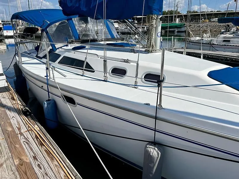 Slide: The Image of 2000 Catalina 320 sailboat docked at marina with blue canopy and fenders. - 3