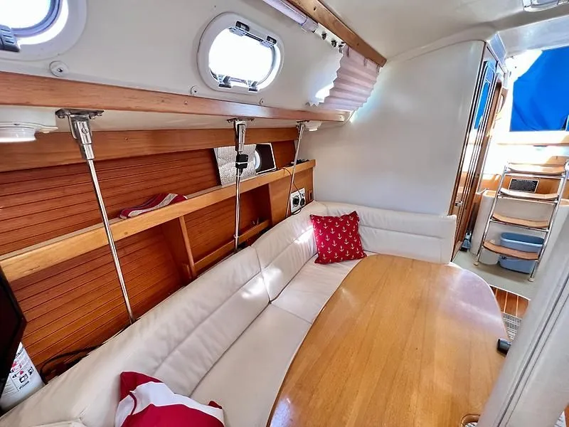 Slide: The Image of Interior of a 2000 Catalina 320 sailboat with cozy seating and wooden accents. - 34
