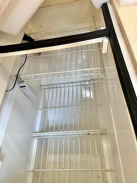 Slide: The Image of Empty refrigerator interior with wire shelves in a 2000 Catalina 320 model. - 38