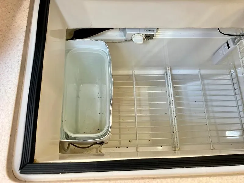 Slide: The Image of Empty refrigerator interior with a plastic container, Catalina 320, 2000 model. - 39