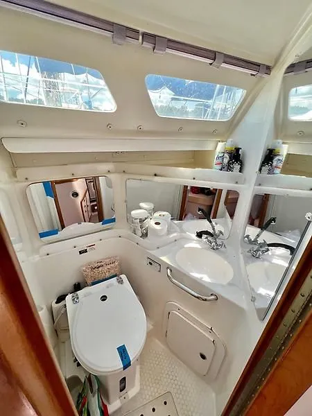 Slide: The Image of Interior of 2000 Catalina 320 yacht bathroom with toilet, sink, and mirrors. - 44