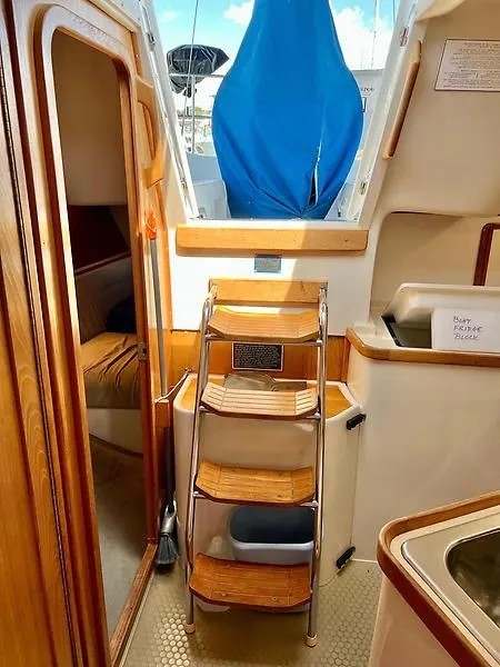 Slide: The Image of Interior of a 2000 Catalina 320 sailboat, featuring wooden steps and cozy cabin space. - 48