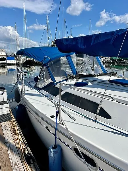 Slide: The Image of Catalina 320 sailboat, 2000 model, docked at marina with blue canopy and clear skies. - 5