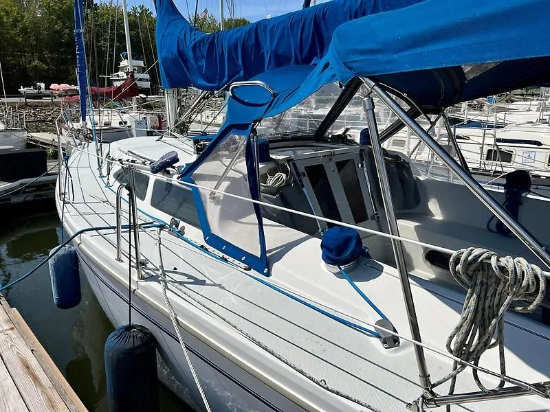 Slide: The Image of 2000 Catalina 320 sailboat docked, featuring blue canvas covers and rigging. - 9