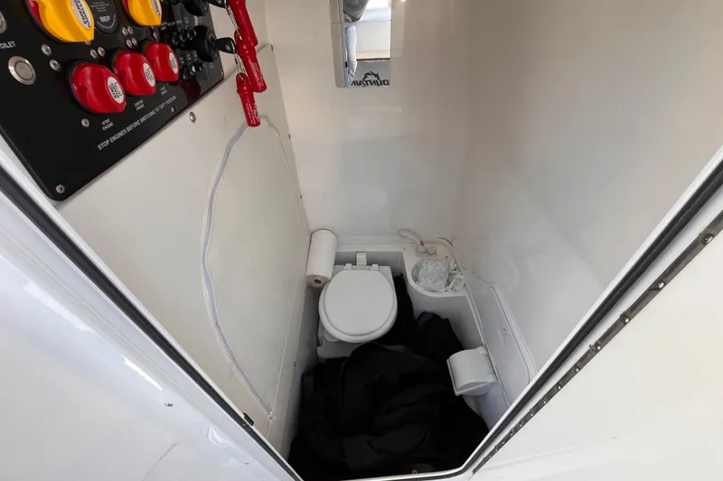 Slide: The Image of Interior of a 2019 Fountain 38 Center Console boat with a compact bathroom setup. - 11