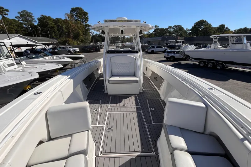 Slide: The Image of 2019 Fountain 38 Center Console boat with spacious seating and sleek design in a marina setting. - 14