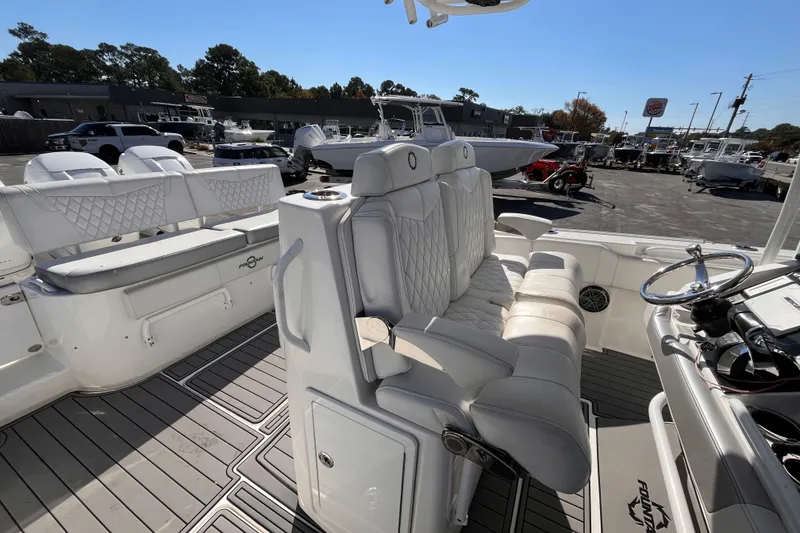 Slide: The Image of 2019 Fountain 38 Center Console boat interior with white seating and steering wheel. - 7