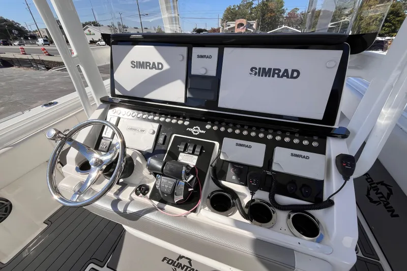 Slide: The Image of 2019 Fountain 38 Center Console boat dashboard with Simrad displays and steering wheel. - 9