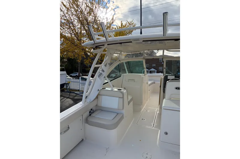 Slide: The Image of 2012 Pursuit DC 265 Dual Console boat interior with seating and helm, under a clear sky. - 2
