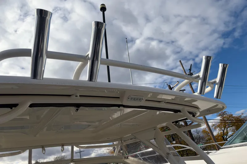Slide: The Image of 2012 Pursuit DC 265 Dual Console boat with rod holders against a cloudy sky. - 4