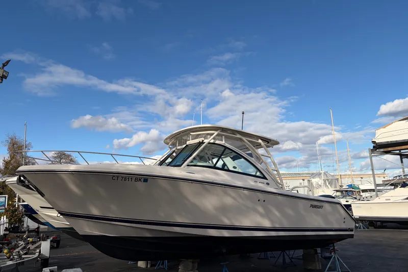 Slide: The Image of 2012 Pursuit DC 265 Dual Console boat on display under a clear blue sky. - 5