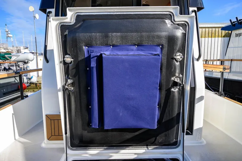 Slide: The Image of 2023 Targa 27.2 boat with blue canvas cover on rear deck, docked at marina. - 10