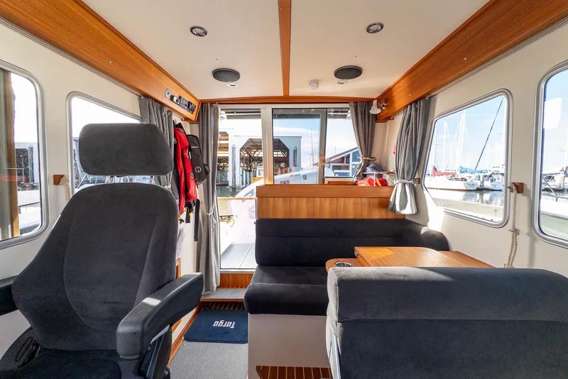 Slide: The Image of Interior of 2023 Targa 27.2 boat, featuring seating and windows with marina view. - 21