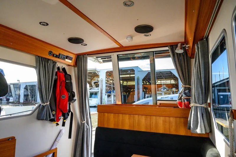 Slide: The Image of Interior of 2023 Targa 27.2 boat with wooden accents and dockside view. - 27