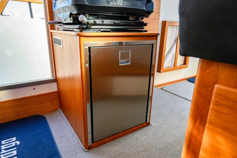 Slide: The Image of Interior of 2023 Targa 27.2 boat featuring a compact stainless steel fridge. - 30