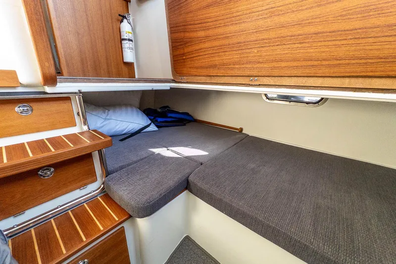 Slide: The Image of Cozy cabin interior of 2023 Targa 27.2 boat with wooden accents and gray cushions. - 31