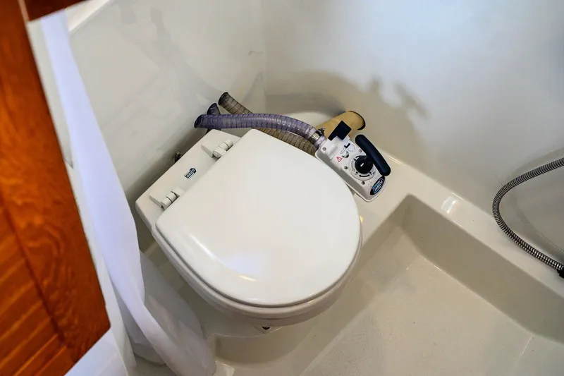 Slide: The Image of 2023 Targa 27.2 marine toilet with manual pump in compact bathroom setting. - 34