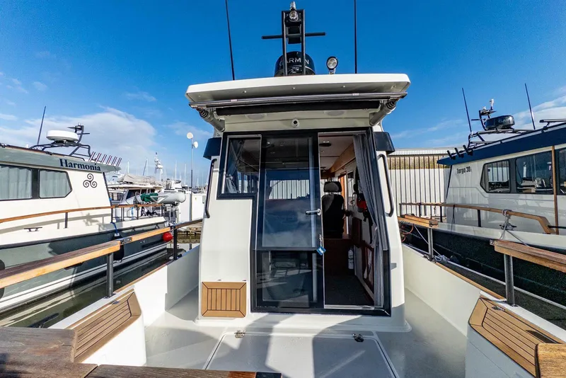 Slide: The Image of 2023 Targa 27.2 boat docked, showcasing rear deck and cabin entrance. - 4