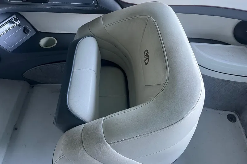 Slide: The Image of Interior of a 1995 Cobalt 252 boat featuring a cushioned seat and control panel. - 12