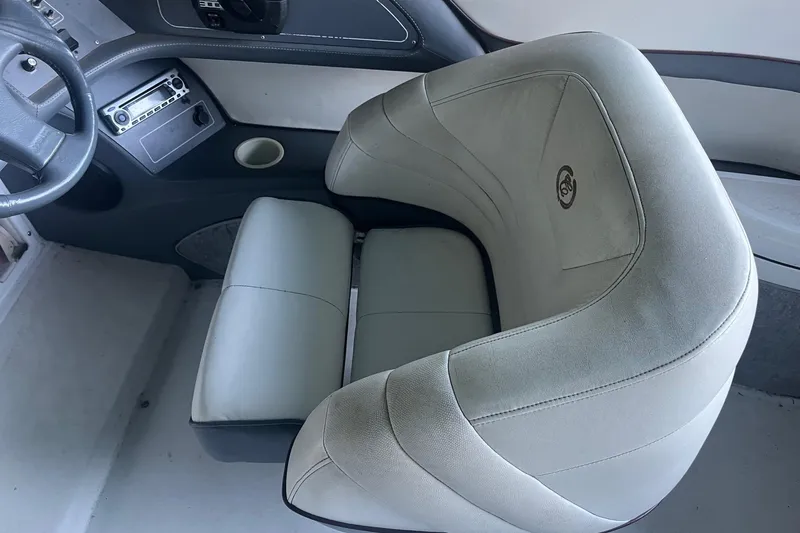 Slide: The Image of Interior of a 1995 Cobalt 252 boat featuring a plush captain's chair and dashboard. - 13