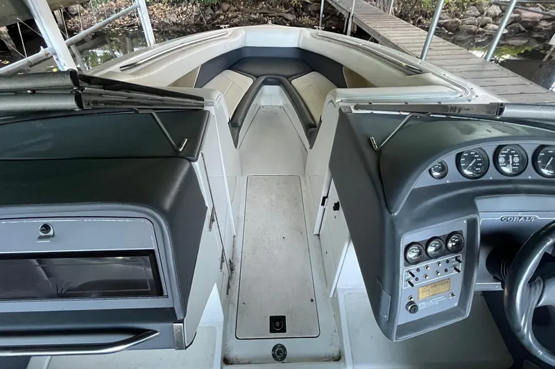 Slide: The Image of 1995 Cobalt 252 boat interior with dashboard and seating, docked by a wooden pier. - 16