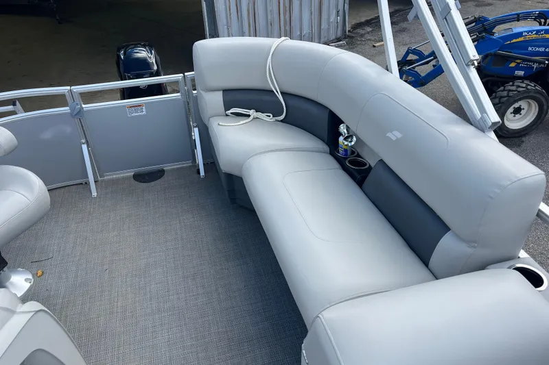 Slide: The Image of 2024 Starcraft LX 16 R pontoon boat interior with gray seating and cup holders. - 5
