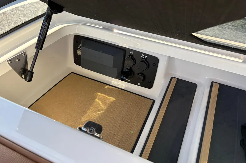 Slide: The Image of 2022 Nautique Super Air Nautique G25 Paragon storage compartment with control panel. - 26