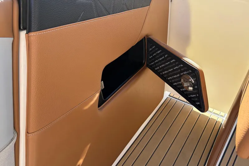 Slide: The Image of 2022 Nautique Super Air Nautique G25 Paragon interior detail with tan leather and storage compartment. - 32