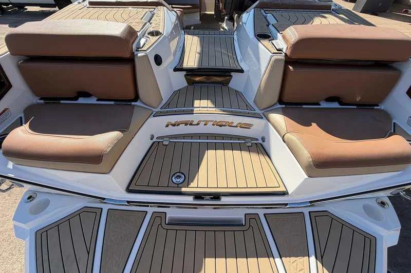 Slide: The Image of 2022 Nautique Super Air Nautique G25 Paragon boat interior with tan seating and teak flooring. - 78