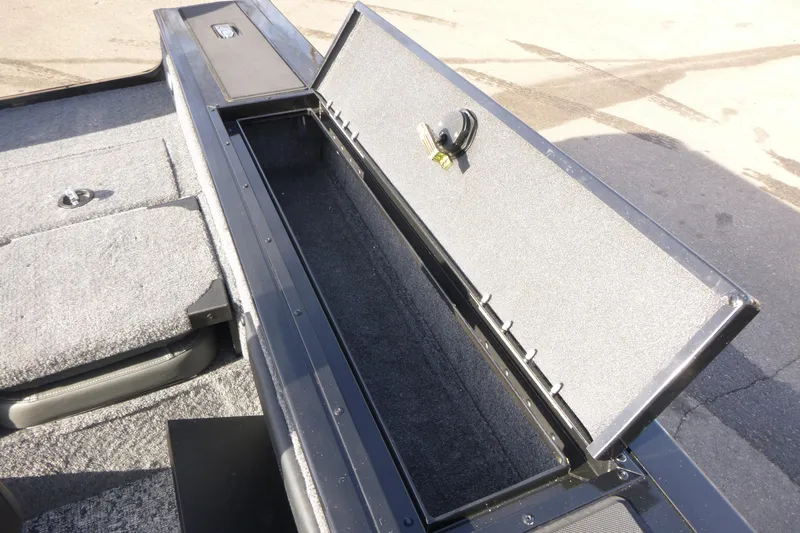 Slide: The Image of 2026 Tracker Targa V-19 Combo boat interior with open storage compartment and carpeted flooring. - 16