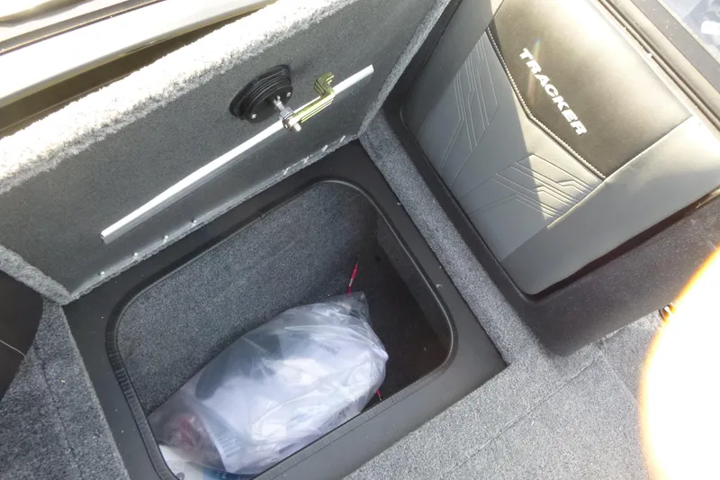 Slide: The Image of 2026 Tracker Targa V-19 Combo boat storage compartment with carpeted interior and Tracker branding. - 36