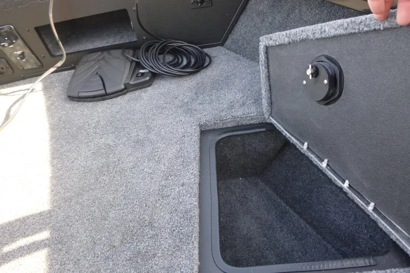 Slide: The Image of 2026 Tracker Targa V-19 Combo boat interior with open storage compartment and coiled cable. - 37