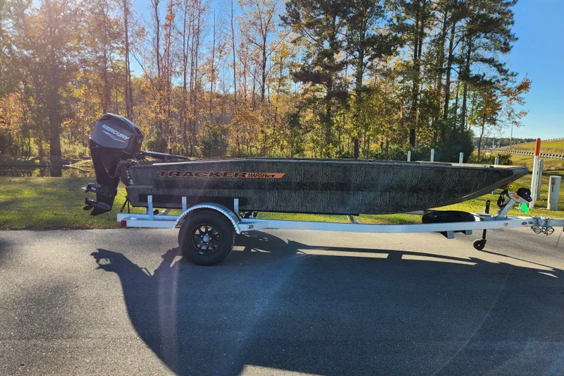 The Image of 2026 Tracker Grizzly 1756 T Marsh boat on trailer, parked outdoors in sunny setting. - 0